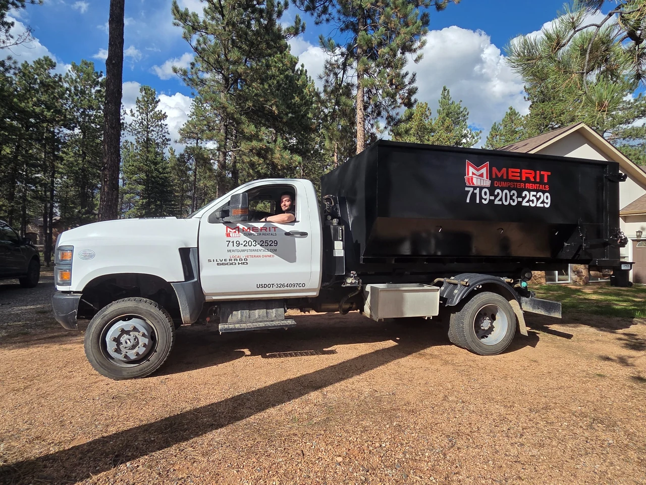 Ryan with the Merit Dumpster Rentals truck and roll-off dumpster